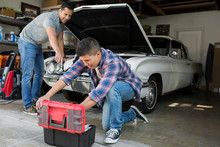 Father And Son Restoring Vintage Car Engine Garage