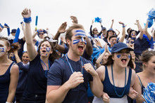 Enthusiastic Crowd In Blue Cheering At Sports Event
