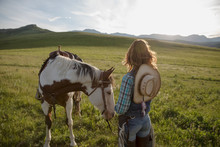 Pensive Female Rancher With Horse Sunny Remote Field