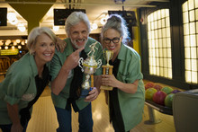 Portrait Smiling Bowling Team Holding Trophies Bowling Alley