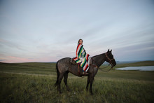 Portrait Female Rancher On Horseback Wrapped In Blanket
