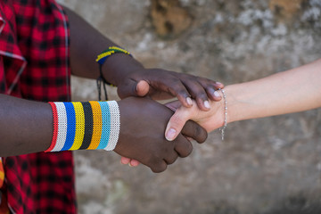 masai tribal man with a caucasian girl making a handshake in the street on the island of zanzibar, t