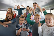 Portrait Confident School Kids Gesturing On School Bus