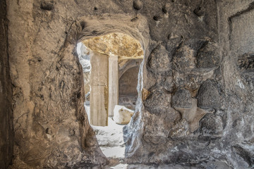 Ancient caves of Uplistsikhe Georgia near the Mtkvari River used by Pagans and Christians - doorway leading into another room with carved storage areas