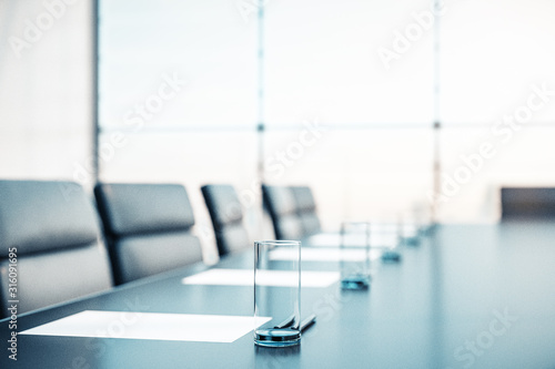 Fotomural Close up of conference room with glasses of water on the table with papers, armchairs and a large window
