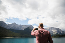 Man Photographing Remote Mountains And Lake With Camera Phone