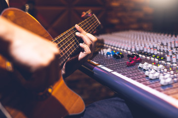 Wall Mural - male musician playing acoustic guitar for recording in home studio