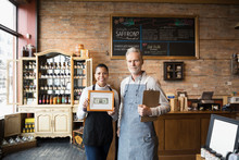 Portrait Confident Spice Shop Owners Holding Framed First Dollar Bill