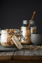 Organic Homemade Granola Cereal With Oats, Nuts And Dried Berries. Muesli In A Glass Jar On The Dark Backround. Healthy Vegan Breakfast Or Snack. Proper Nutrition Concept