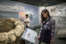 Curious Girl Student Looking At Exhibit On Field Trip In War Museum