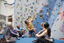 Instructor Talking To Group Below Rock Climbing Wall