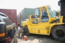 Mechanics Fixing Heavy Machinery In Sunny Industrial Container Yard