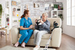 © DC Studio - Elderly age woman sitting on couch with nurse