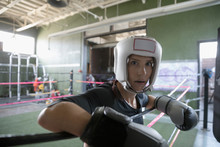Portrait Confident Female Boxer Wearing Protective Headwear And Boxing Glove In Boxing Ring