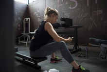 Woman Weightlifting, Resting And Listening To Music With Headphones And Mp3 Player At Gym