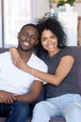 Sticker - Portrait of happy young black couple posing hugging at couch