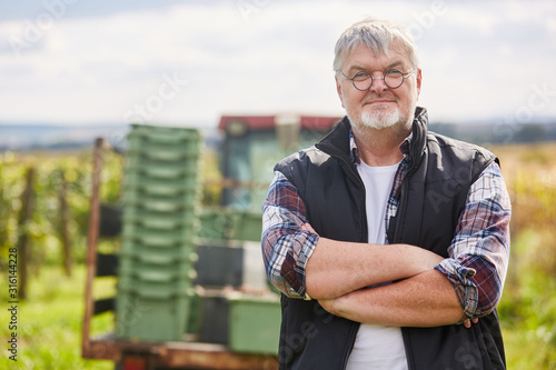 Fotografía Weinbauer steht zufrieden auf seinem Weingut