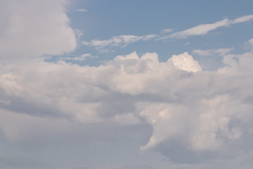 Pale white cumulus lush clouds against a blue sky