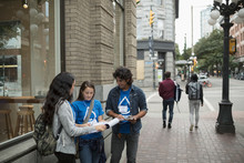 Political Young Adults Canvassing With Petitions On Urban Sidewalk