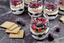 Homemade Layered Red Berry Fruit, Cookie Crumbs And Cheesecake Cream Dessert In Glasses