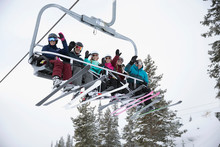 Portrait Smiling Family And Friend Skiers Riding Chair Lift At Ski Resort