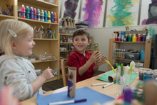 Preschool Boy And Girl Making Art And Craft Projects In Classroom
