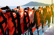 Orange Life jackets are safety devices that are hung on a passenger boat. Life jackets are used to prevent drowning.