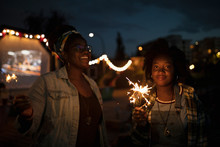 Happy Young Women With Sparklers At Movie In The Park