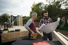 Men With Blueprints At Construction Site