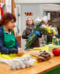 Two florists work in a nursery.