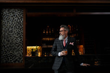 Fashionable Hipster Businessman With Beard Drinking Cocktail In Bar