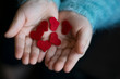 red small hearts on the childs hands. Child holding red hearts.