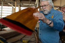 Senior Man Making Wooden Oar In Creative Workshop