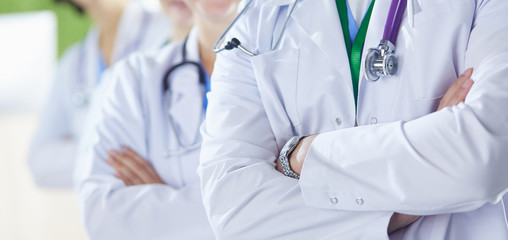 Happy medical team comprising male and female doctors smiling broadly and giving a thumbs up of success and hope