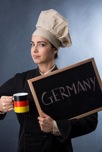 Cuoca Tedesca Mostra Una Lavagna Con Scritto Germany E Beve Da Una Tazza Con I Colori Della Germania