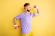 © LIGHTFIELD STUDIOS - side view of sportsman working out with pink dumbbells on yellow