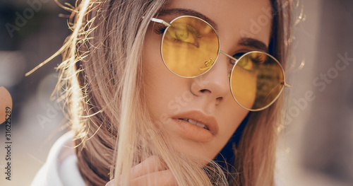 Portrait of beautiful stylish blonde woman in yellow sunglasses in outdoor Poster Mural XXL