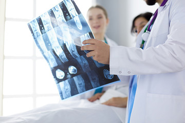 Attractive doctor examining an x-ray and smiling at the camera