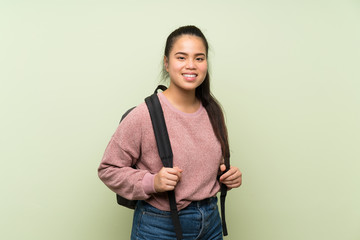 Wall Mural - Young teenager Asian girl over isolated green background with backpack