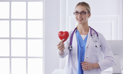 Doctor with stethoscope holding heart, isolated on white background