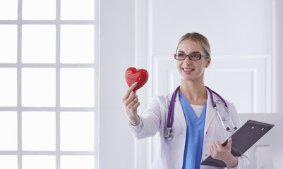 Doctor with stethoscope holding heart, isolated on white background