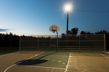 Basketball Court Lit By Floodlight At Night