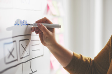 Wall Mural - female web developer with marker sketching website on whiteboard