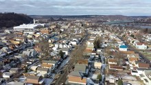 A Slowly Orbiting Winter Aerial Establishing Shot Of The City Of Monaca, Pennsylvania, A Small Rust Belt Town. Factories And Bridges On The Ohio River, In The Distance. Pittsburgh Suburbs.  	