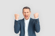 © Viktoriia - Freestyle. Mature businessman standing isolated on white hands up shouting motivated