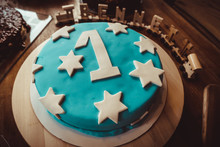 A Birthday Cake For The Special Little One Turning One. A Blue Decorated Cake With A White One And Stars.