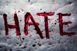 The word hate painted by blood on a metal table