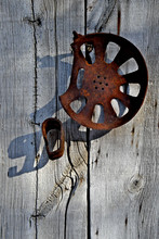 Rusted Tractor Seat And Metal Band On Weathered Barn Wall