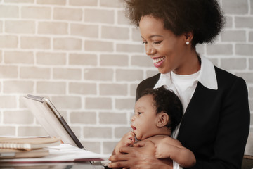 Wall Mural - african american mother and businesswoman taking care of her child while working at home