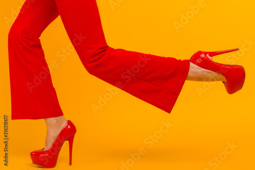 Cuadros en Lienzo The business woman running somewhere hurrying up isolated on yelow background